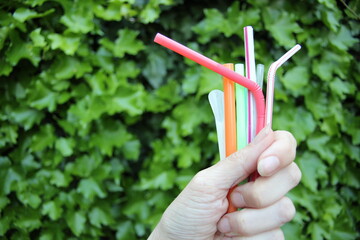 straws - hand holding plastic single use straws disposable 