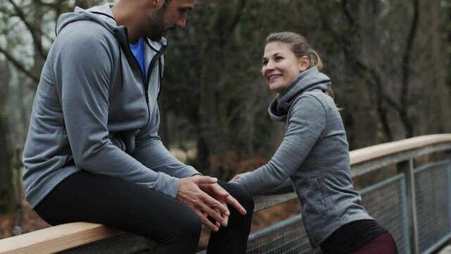 MS TD SLO MO Man and woman stretching on bridge over Isar River / Munich, Bavaria, Germany
