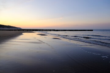 Obraz premium Beautiful sunset colors on the beach of sea and amazing reflection in water.