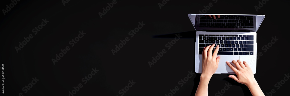 Poster person using a laptop computer from above