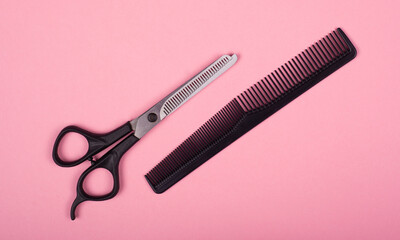 scissors and comb on a pink background, hairdressing concept.barber tools