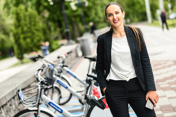 Use environmentally friendly modes of transport. Cheerful young businesswoman in smart casual wear...