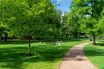 Beautiful Green Lawn in The Palace Park (Slottsparken) in the centre of Oslo, Norway. People relaxing on the lawn. - obrazy, fototapety, plakaty