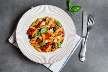 Pasta fusilli with cherry tomatoes, basil and olives. Homemade pasta 