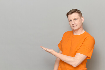 Portrait of happy man pointing with hand at empty place and smiling