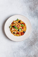 Pasta fusilli with cherry tomatoes, basil and olives. Homemade pasta 