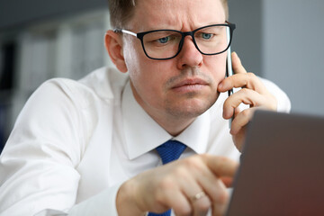 Man in office focused information listens on phone