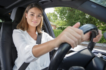 happy young woman in her car while driving a car