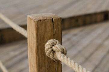 Wooden post. Sea rope. Knot.