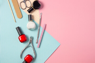 Fototapeta na wymiar Tools for manicure on a pink and blue background. Nail files, scissors and nail polishes top view. Nail Salon, Beauty Salon