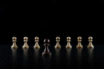 chess concept of not like everyone. white pawn is in the row of black pawns on black background