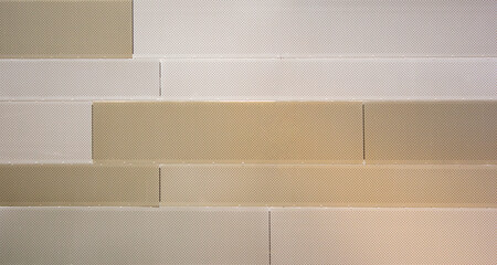 Beige metal wall made of blocks with small holes