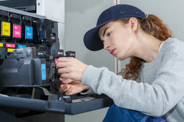 technician inspecting ink in industrial photocopier