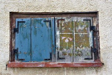 Verwitterter Fensterladen in einer alten Hausfassade