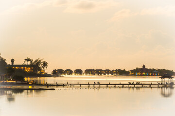 Sunset view of luxurious cottages on the ocean at a resort in the Caribbean.