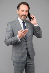 Naklejka premium confident male talk on mobile phone. At work. trying to help someone. ceo in office jacket use smartphone. mature businessman answer email. professional business man in formal suit