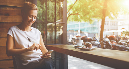  smiling hipster girl calling with cell telephone while relaxing after walking in summer day