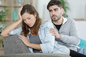 upset couple sitting after arguing on couch