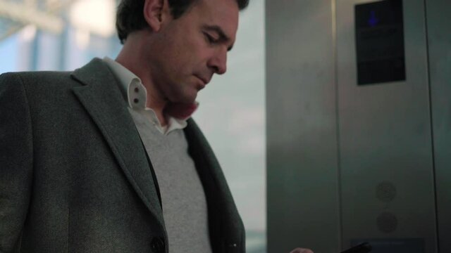 TS CU Businessman using phone in elevator / Milan, Italy