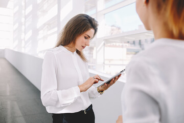 Fototapeta premium Female skilled office worker use digital tablet for consulting with managing director
