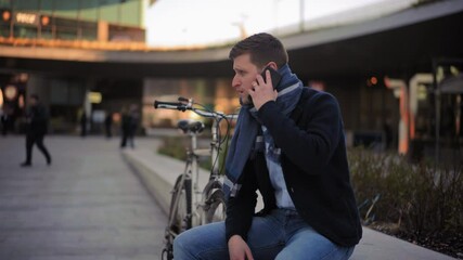 MS Businessman sitting on wall and talking on phone / Milano, Milano, Italy
