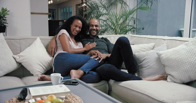 MS PAN Couple reclining on sofa in living room / Claremont, Cape Town, South Africa