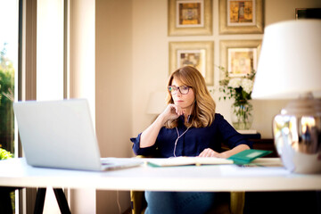 Shot of woman sitting behind her laptop and working from home