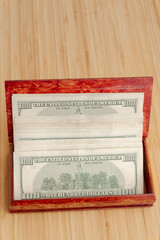 American hundred dollar bills in large quantities in a wooden box