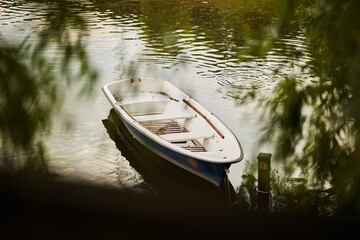 Obraz premium White wooden boat on the lake. White wooden boat with a brown bottom top view. Boat on the lake.