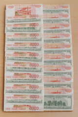 A large number of American hundred dollar bills and Russian five thousand dollar bills