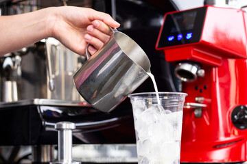 Ice coffee preparation preparation service concept. Barista makes espresso in a cafe; close-up of milk pouring. Freshly ground coffee close-up