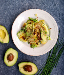 Avocado salad with potatoes and seeds on blue textured background, top view. The concept of clean, diet, vegan, vegetarian, healthy food
