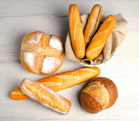 Bakery - Rustic and golden bread and buns on white wooden background.Top view, flat lay.