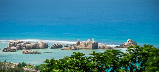 Fototapeta na wymiar Panoramic view of famous granite rocks in blue sea at La Digue, Seychelles. fluffy turquoise sea