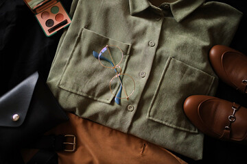 Composition from clothes. Shirts and a jacket with loafers on a dark background. Clothing. 
