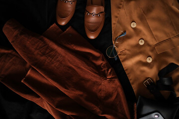 Composition from clothes. Shirts and a jacket with loafers on a dark background. Clothing. 