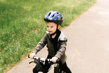 Happy little boy riding a bike running in the Park