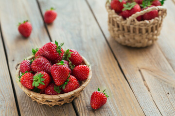 Bowl of red juicy strawberries on rustic wooden table. Healthy and diet snack food concept.