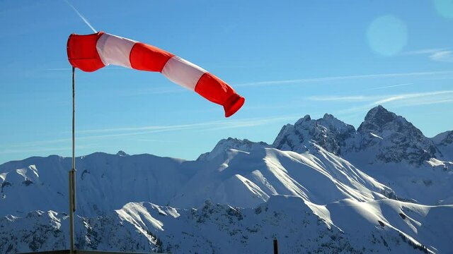WS Windsock against snowcapped mountain range  / Oberstdorf, Bavaria, Germany