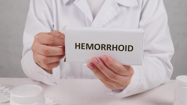 Proctologist with pack of hemorrhoidal suppositories, closeup