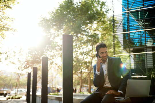 Smiling Businessman Working At A Bench Outside His Office Building