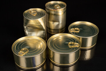 Metal cans with food on a dark table. Preserved meal with a long shelf life.
