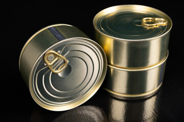 Metal cans with food on a dark table. Preserved meal with a long shelf life.