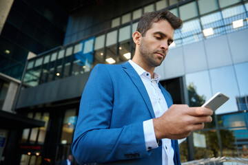 Young businessman sending a text message on his cellphone