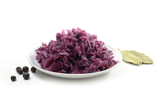 Portion of cooked red cabbage, juniper berries and bay leaves, isolated on a white background, copy space