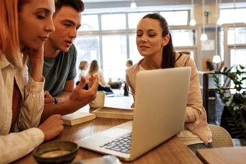 Group of  university students hangout in college cafe library  and preparing for lecture.
