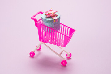 Blue present box with pink bow in a shopping cart
