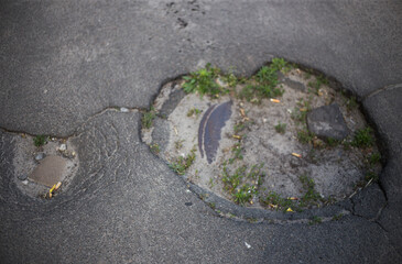 Broken asphalt and cracks on the road surface