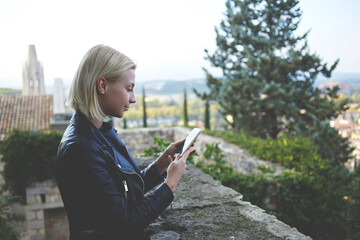 Young attractive woman with good mood enjoying beautiful city landscape