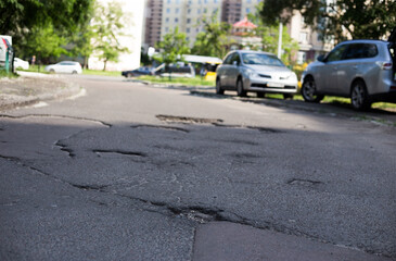 Broken asphalt and cracks on the road surface